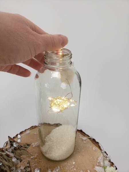Pour some Epson salt into the display container and slip the star in to dangle above the snow