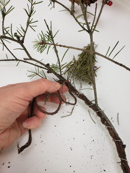 Simply wrap the wire from the needle tree around the bark wire and the twig