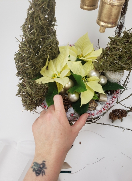 Three well dressed poinsettia plants nestle into the bowl