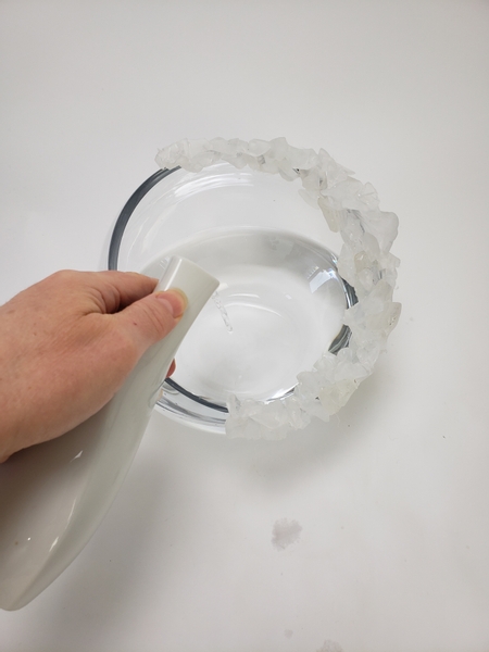 Carefully fill the display container with water without getting the glass chips wet