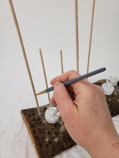 Paint the dowel sticks with wood glue