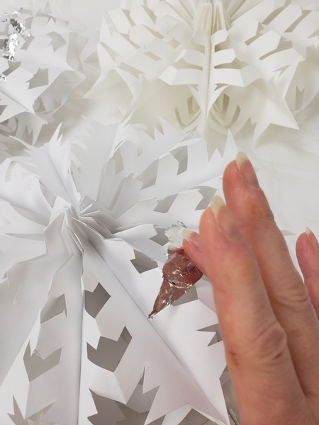 Tear rough and random sized pieces  of silver leaf and gently drop it down to settle on the glue