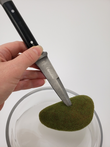 Use a sharp knife to cut into a fake moss pebble