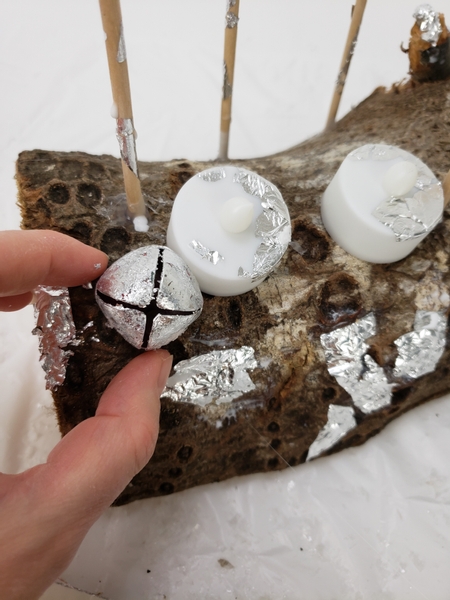 Use hot glue to glue some of the bells to the log
