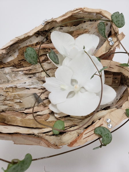 Pure white orchids in a floral design