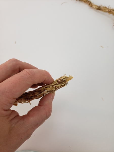 Fold the tip of the straw garland over and secure it with hot glue