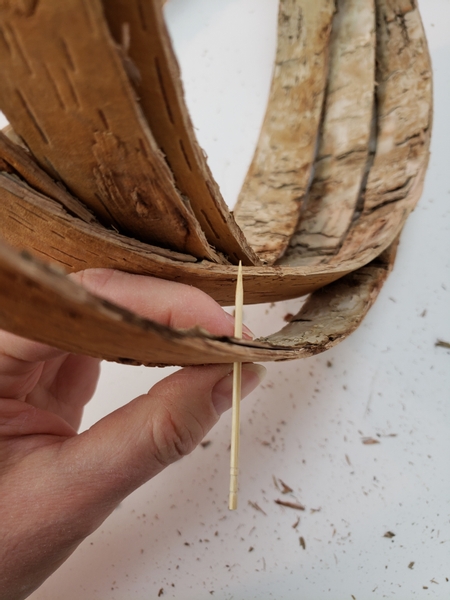 Press the cocktail skewer through the stack of bark strips