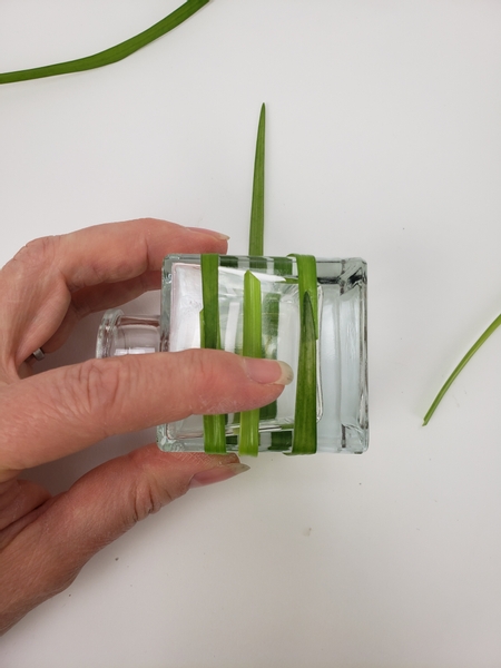 And add the third blade of grass around the glass container