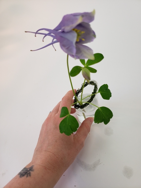 Turn the flower to find a balance point where it naturally remains upright and supported by the wreath