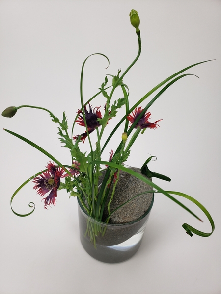 Keep flowers in position with a rock in a floral arrangement