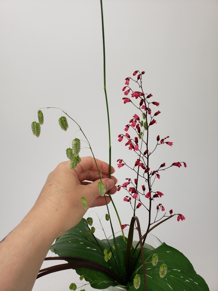 Set the design back into the water filled vase and adjust the height by adding in a few more grasses.