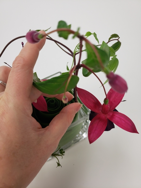 And slip the fuchsia flowers between the leaf swirl so that it stands perfectly upright