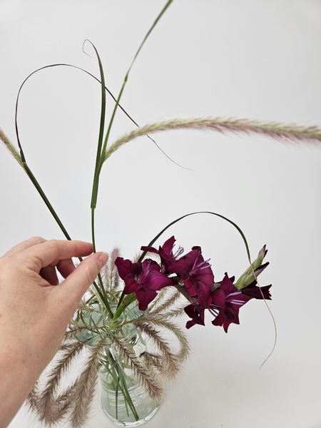 Curving some of them to sweep elegantly over the gladiolus