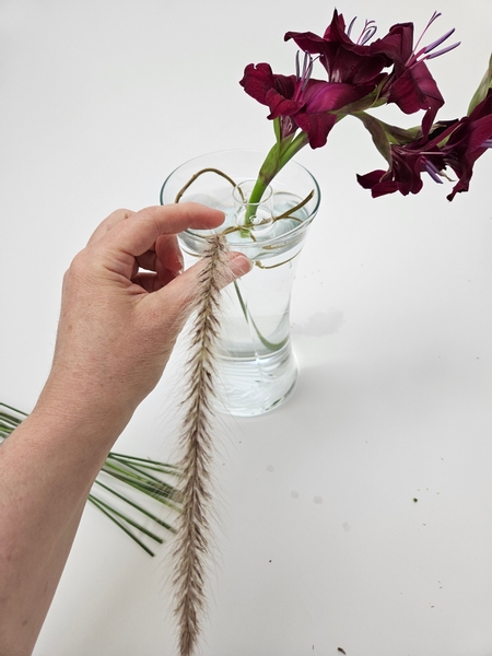 Place stems of long and elegant purple fountain grasses to sweep over the edge of the container