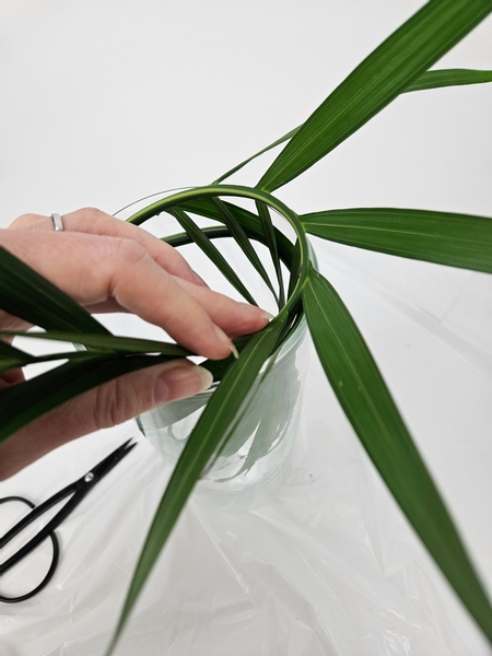 Concentrate on spacing out the leaflets both inside the container and those that fall above the container to radiate out neatly and evenly spaced