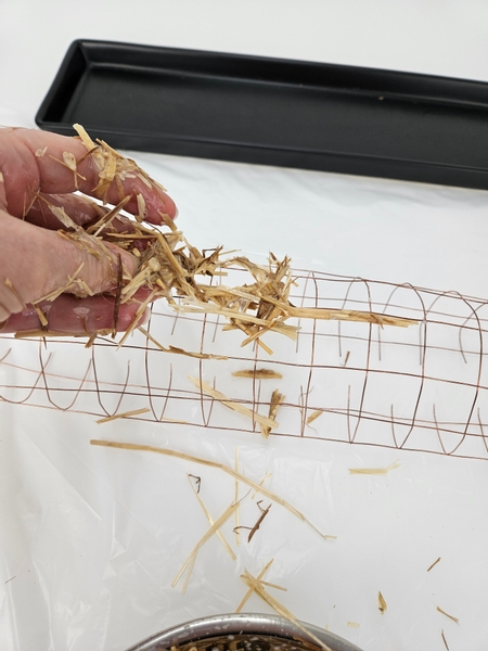 Scatter the straw onto the wire mesh