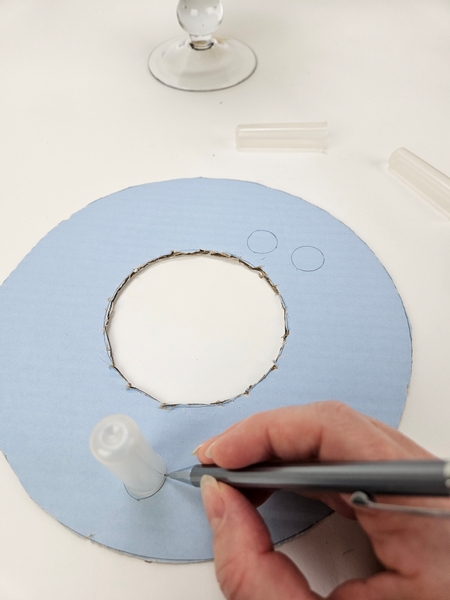 Trace out three water tube shapes onto the cardboard disk