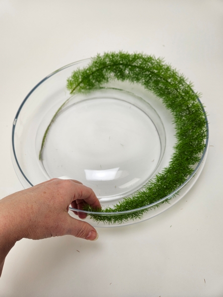 Curve the fern between the two glass containers