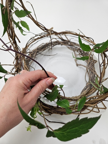 Inserting each stem exactly the same as the wreath twirl so that the fresh stems blend in seamlessly with the dried ivy vines