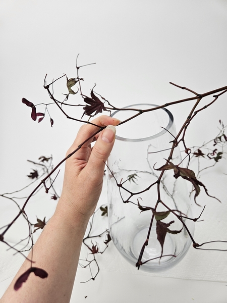 Place the first twig over the top of a large container to shape a natural grid to keep your fresh flowers in place