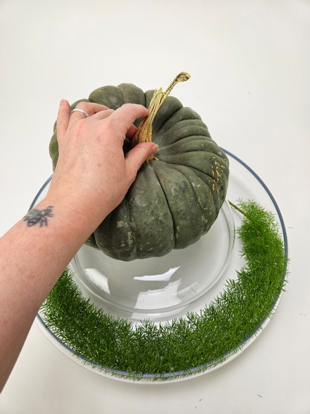 Position the pumpkin on the middle glass container