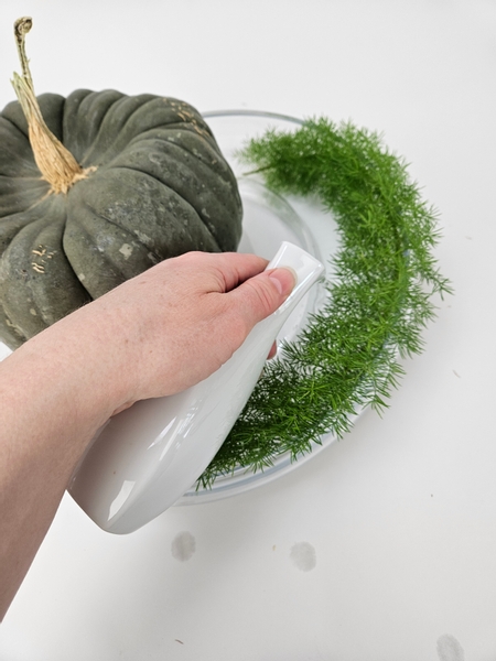 Pour water into the container taking care to leave the container dry where the pumpkin rests