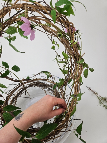 So that the flower heads are displayed at the top and the stems are supported in the wreath below