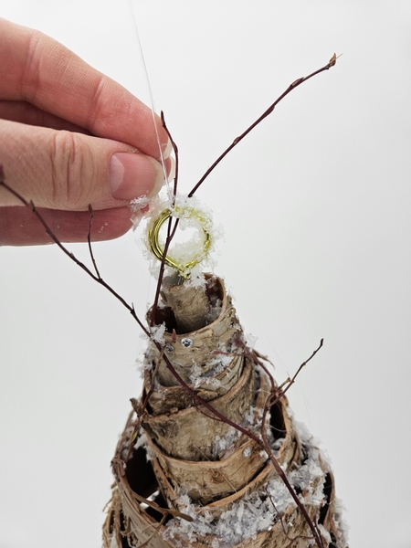 Paint the hook on the top with wood glue and cover with a sprinkling of snow to conceal