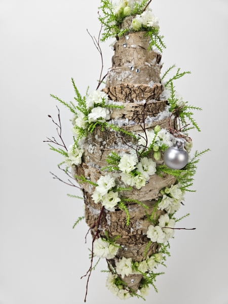 Snow covered bark and kalanchoe floral display for  winter Christmas