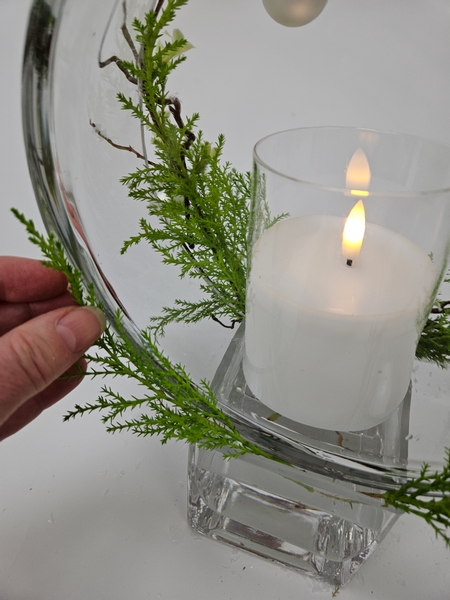 Turn the design around and add a few cypress branches to follow the glass curve into the back