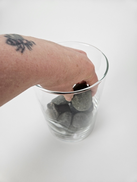 Place a few pebbles in the bottom of a glass container