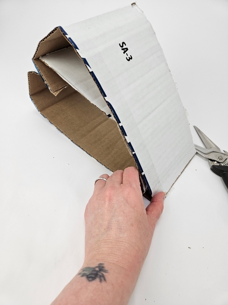 Fold the cardboard over and place the shorter cardboard into the heart shape and secure all three pieces at the tapered end