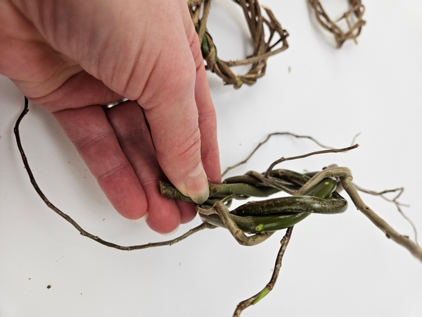 Make sure the willow wreath cut stem end extends out of the woven wreath so that you can balance the design on it