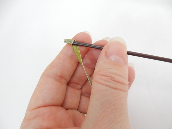 Add a small drop of glue to the tip of a blade of grass