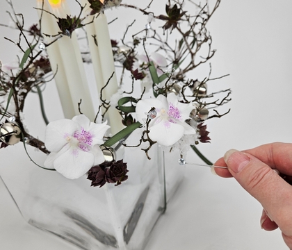 Balance a Jingle bell tabletop twig set on a glass giftbox vase