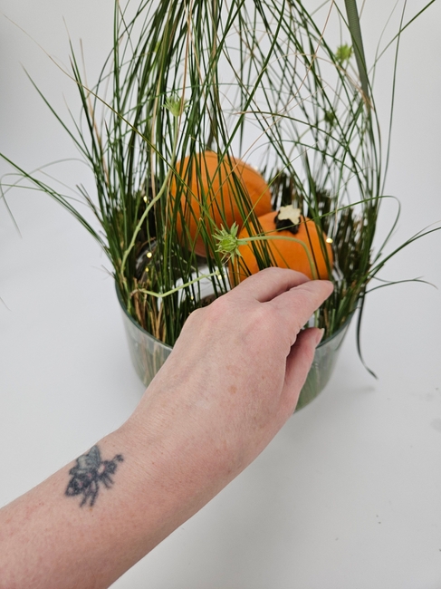Rest a few bits of grass together to create a shelter for pumpkins, and fairy lights and delicate petals